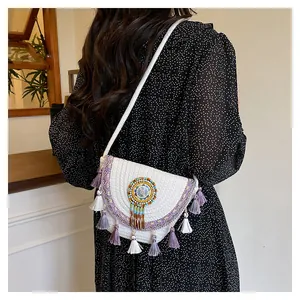Dettaglio borsa a tracolla intrecciata con nappe viola e ricami di perline su modella