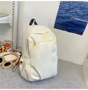 Vue détaillée du sac à dos en toile crème avec plusieurs poches dans un décor d'étude