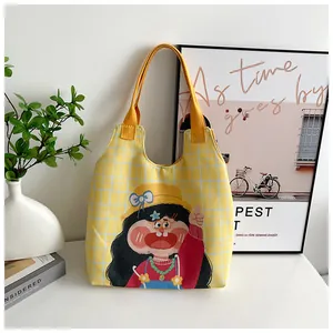 Detail of yellow checkered canvas tote bag featuring a cute cartoon girl illustration
