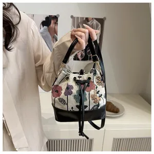 Detail of floral jacquard bucket bag with black leather trim and drawstring closure