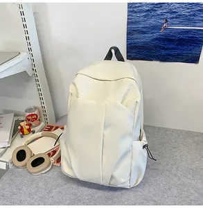 Détail du sac à dos beige avec plis 3D minimalistes et poche latérale à cordon de serrage