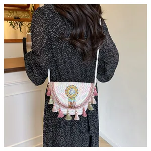 Dettaglio della borsa a tracolla intrecciata a mano con nappe boho e ricami