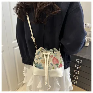 Detail of vintage floral jacquard bucket bag with white drawstring and adjustable strap