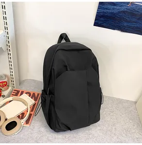 Détail d'un sac à dos en nylon noir imperméable avec poche avant et cordon de serrage