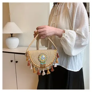 Dettaglio di borsa in paglia bohémien con perline colorate e nappe su borsa intrecciata