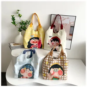 Detail view of four Japanese style canvas tote bags with cartoon girl prints and plaid patterns