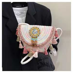 Dettaglio della borsa a tracolla intrecciata boho con motivi a zigzag e nappa di perline