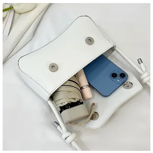 Interior view of white crossbody bag showing spacious storage for phone and umbrella