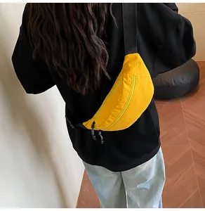 Rear view of a yellow waterproof waist bag with adjustable black shoulder strap