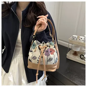 Detail showing the floral woven texture and drawstring closure of the bucket bag