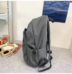 Vue détaillée de la poche latérale à cordon d'un sac à dos gris foncé minimaliste