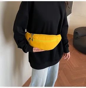 Detail of a bright yellow waterproof waist bag with durable texture and metal zippers