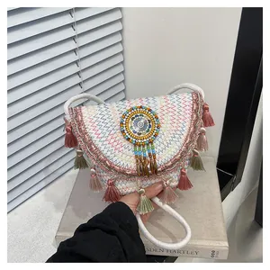 Dettaglio della borsa bohémien tessuta a mano con ricami a zigzag e nappe colorate