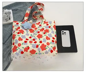 Close-up of floral canvas tote bag with star plush charm and shoulder strap detail