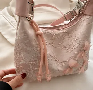 Detalle del bolso de encaje rosa con lazo de malla 3D y herrajes de metal pulido