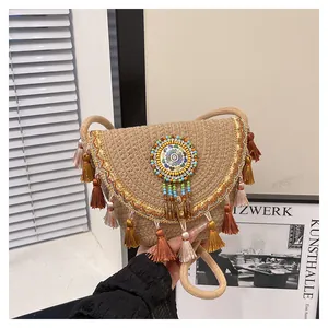 Dettaglio borsa in paglia boho con motivi di perline colorate e frange multicolore a strati