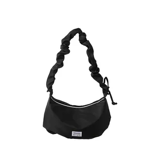 Sac baguette demi-lune noir avec bandoulière plissée et détail d'étiquette mode