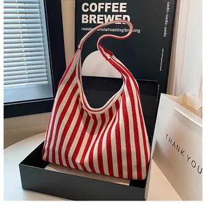 Detalle del bolso tote de lona con rayas rojas y blancas en caja de regalo