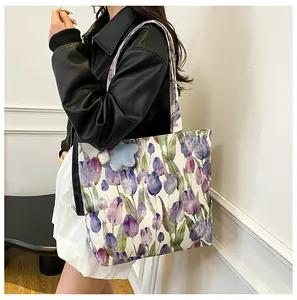 Detail view of floral canvas tote bag with purple tulips and blue star plush charm