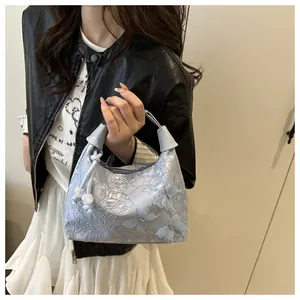 Detalle de bolso de encaje azul claro con mariposas 3D y adornos de perlas
