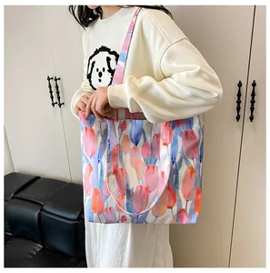 Floral canvas tote bag with tulip patterns shown on shoulder of a model in white