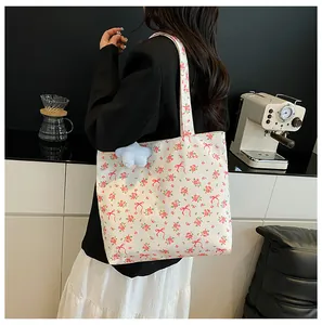 Close-up of floral canvas tote bag featuring a cute blue star plush charm and ribbon print