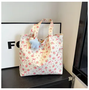 Detail of floral canvas tote bag with pink flower patterns and blue plush star charm