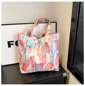 Detailed shot of floral canvas tote bag with pink tulip prints and star plush keychain