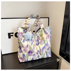 Detail of floral canvas tote bag with purple tulips and blue star plush pendant