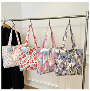 Detail of four floral canvas tote bags with cute blue star plush charms hanging on a rack