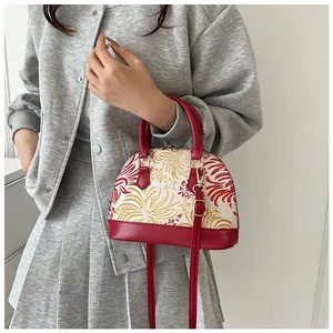 Detail view of a vintage shell handbag with red leather trim and fireworks patterns