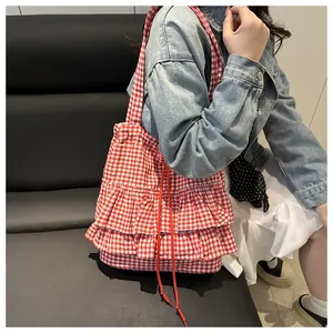 Détail du sac cabas à carreaux rouges et blancs avec volants doux et détails de cordon