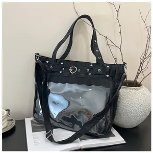 Detail of black tote bag with heart-shaped metal buckle and transparent PVC window