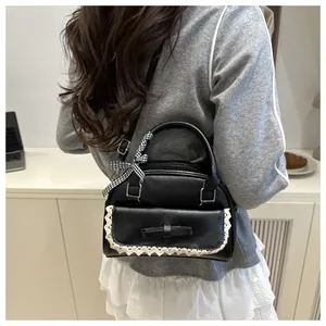 Detail of black Lolita style crossbody bag featuring white lace trim and bow accent