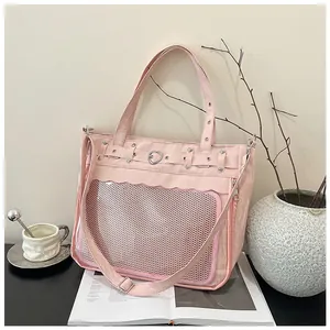 Close-up of pink ita bag featuring heart decor, transparent pocket and studded details