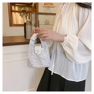 Detail of floral tote bag with lace trim and mint green striped lining interior