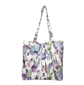 White canvas tote bag with purple tulip floral print and blue star plush charm