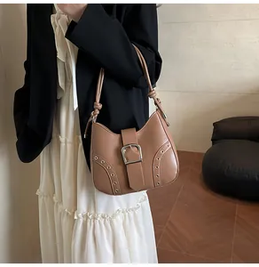 Detail of vintage brown leather shoulder bag with metallic buckle and knot strap detail