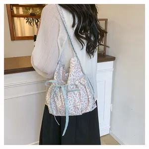 Floral shoulder bag with blue checkered bow detail and delicate flower patterns