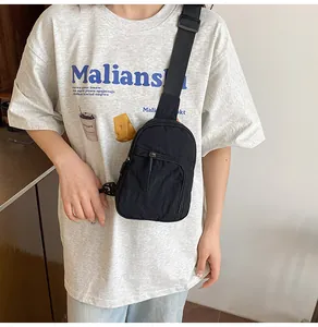 Détail du sac de poitrine noir en nylon montrant la poche zippée et la bandoulière