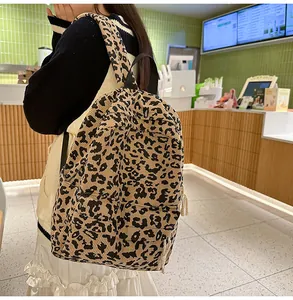 Detailansicht des Cord-Rucksacks mit Leopardenmuster, schwarzen Reißverschlüssen und Griff