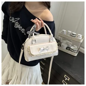 Detail of white PU leather crossbody bag with lace trim, bow, and checkered ribbon