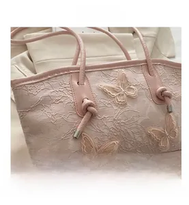 Detail of pink lace embroidery tote bag with 3D butterfly appliques and knotted strap