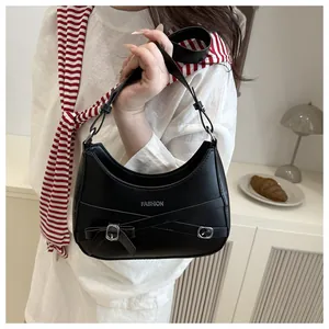 Détail du sac sous l'aisselle en cuir PU noir avec lanières et boucle en métal nœud