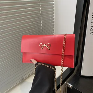 Fashionable red envelope bag with gold bow clasp and chain strap for women