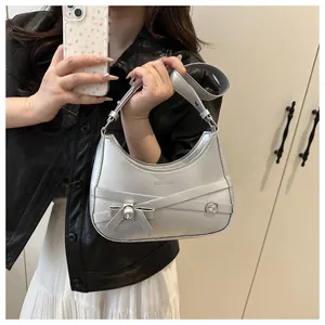 Sac bandoulière demi-lune argenté avec fini métallique et détail noeud sur modèle