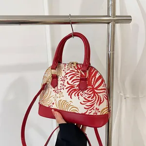Retro shell-shaped crossbody bag with red floral embroidery and double handles