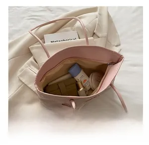 Interior view of pink embroidered tote bag showing large capacity for cosmetics