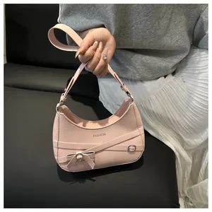 Détail de l'épaule rose en forme de croissant avec boucle en métal et bandoulière croisée