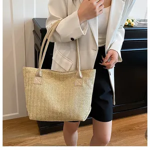 Detail of herringbone woven straw tote bag with reinforced faux leather shoulder strap